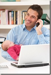 Working Dad Talking On Phone Holding An Infant